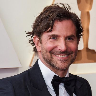 Bradley Cooper is smiling and posing for the cameras.